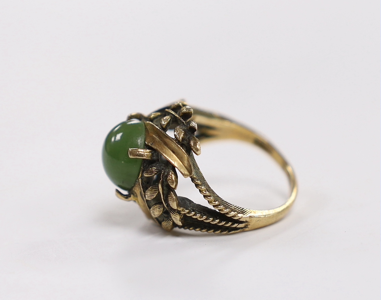 A 10k and oval cabochon jade set dress ring, size L, gross weight 6.2 grams.